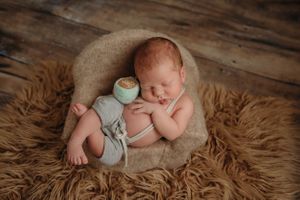 newborn session in Centralia, IL studio session, baby boy, siblings, foliage, newborn prop, advanced posing,