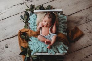 newborn session in Centralia, IL studio session, baby boy, newborn bed, foliage,